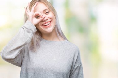 Sarışın genç kadın gülümsüyor, parmakları ile mutlu yüz üzerinden seyir göz el ile ok jest yapıyor izole arka plan üzerinde.