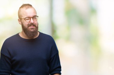 Genç beyaz hipster adam seksi bir ifadeyle, neşeli ve mutlu yüzünü kameraya bakarak göz kırpıyor izole arka plan üzerinde güneş gözlüğü takıyor.