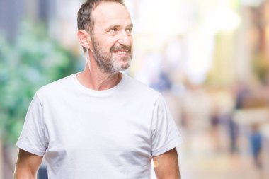 Orta yaş ağarmış komuta sizde görünümlü yan ve dik dik bakma uzağa düşünce gülümseyen izole arka plan üzerinde beyaz t-shirt giyen.