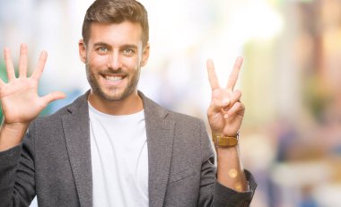 Genç yakışıklı iş adamı gösterilen ve parmakları ile işaret izole arka plan üzerinde kendinden emin ve mutlu gülümseyerek süre yedi numara.