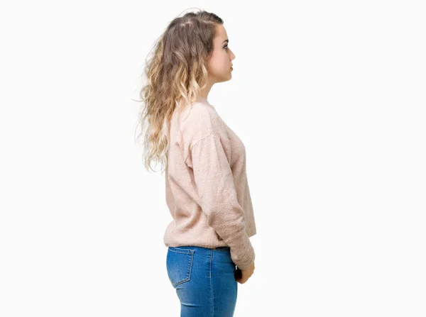 美しい若いブロンドの女性側を分離の背景の上身に着けている Sweatershirt リラックス自信を持って笑顔で自然の顔を持つプロファイル ポーズ — ストック写真