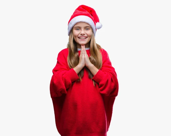 年轻美丽的女孩戴着圣诞节帽子在孤立的背景祈祷与双手一起祈求宽恕微笑自信 — 图库照片