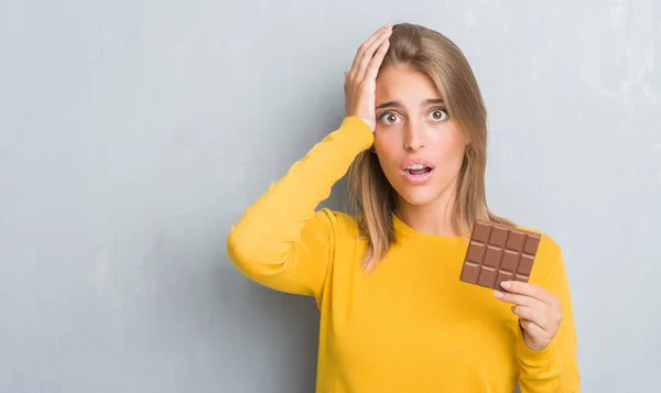Hermosa Mujer Joven Sobre Pared Gris Grunge Comer Barra Chocolate —  Fotos de Stock
