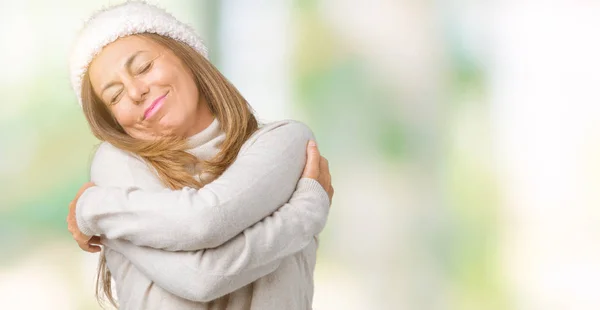 美丽的中年妇女穿着冬季毛衣和帽子在孤立的背景拥抱自己快乐和积极 微笑自信 自爱和自我关怀 — 图库照片
