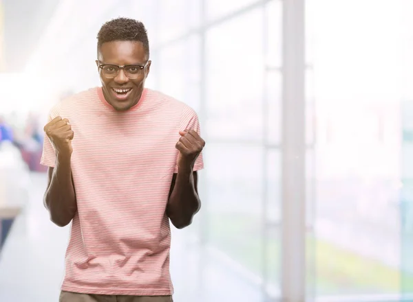 Unga Afroamerikanska Man Klädd Rosa Shirt Firar Överraskad Och Förvånad — Stockfoto