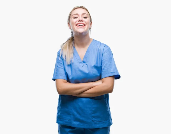 上医療制服を着て若い金髪外科医医師女性は 幸せそうな顔で笑顔組んだ腕のカメラを見て背景を隔離しました 肯定的な人 — ストック写真