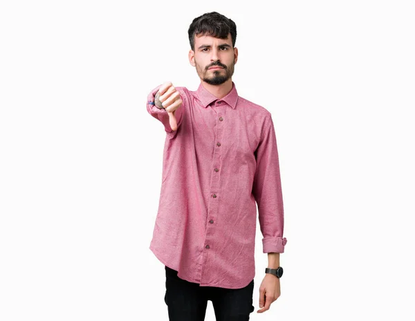 年轻英俊的男人穿着粉红色的衬衫在孤立的背景看起来不高兴和愤怒 表现出拒绝和负面的大拇指向下的姿态 错误的表达 — 图库照片