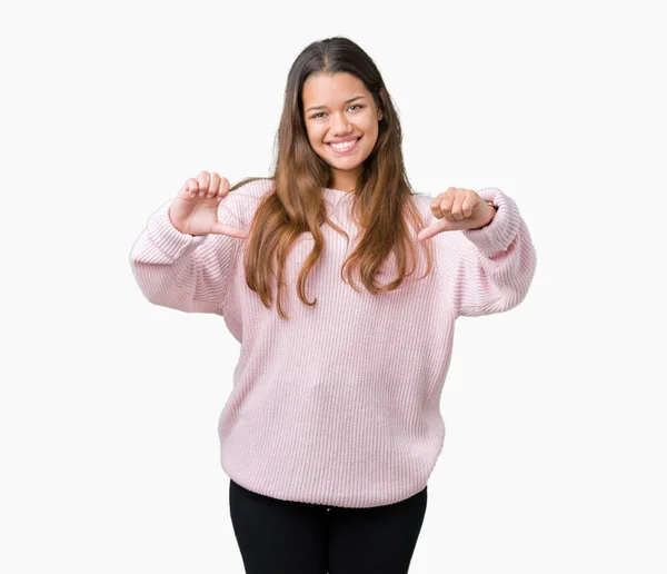 孤立した背景の顔に笑顔と自信を持って 誇りと幸せな指で自分を指して上ピンク冬セーターを着ている若い美しいブルネットの女性 — ストック写真