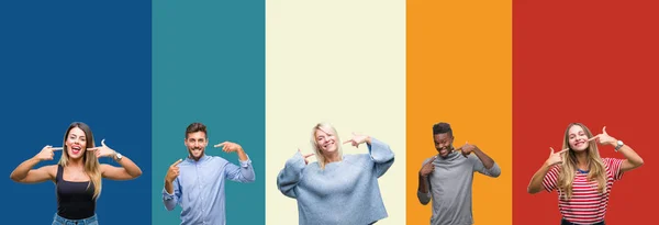 Collage of group of young people over colorful vintage isolated background smiling confident showing and pointing with fingers teeth and mouth. Health concept.
