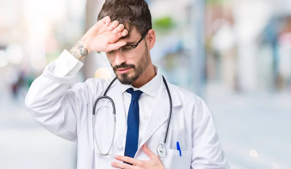 年轻医生在孤立的背景上穿医院外套触摸额头因病发烧 流感和感冒 病毒病而感到病 — 图库照片