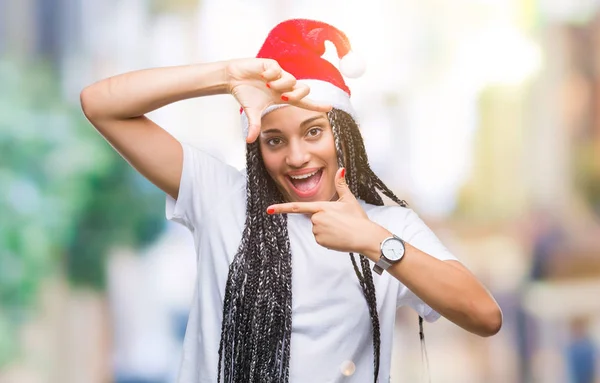 年轻的编织头发非洲裔美国女孩戴着圣诞帽在孤立的背景微笑的框架与手和手指与快乐的脸 创意和摄影理念 — 图库照片