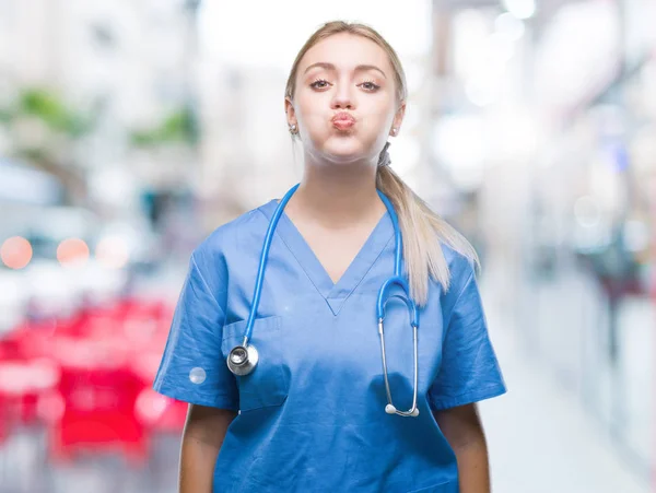 Jovem Cirurgiã Loira Médica Mulher Sobre Fundo Isolado Soprando Bochechas — Fotografia de Stock