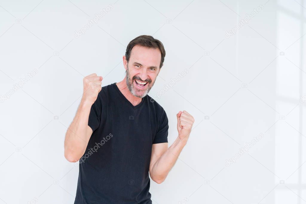 Senior man over isolated background very happy and excited doing winner gesture with arms raised, smiling and screaming for success. Celebration concept.