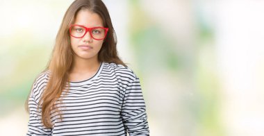 Giyen genç güzel esmer kadın kazak ve kırmızı gözlük yüzünde ciddi bir ifade ile izole arka plan üzerinde çizgili. Basit ve doğal kameraya bakıyor.