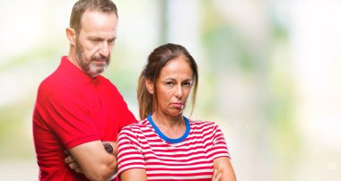 Orta yaş İspanyol çift izole arka plan şüpheci ve sinir, onaylamayan ifade yüz çapraz kolları olan aşık. Negatif kişi.