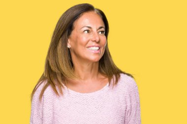 Üzerinde kış kazak giyen güzel orta yaş yetişkin kadın arka plan uzak tarafına gülümseme ile yüzünde, doğal ifade arıyorum izole. Kendine güvenen gülüyor.