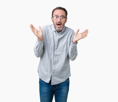 Üzerinde gözlük takan yakışıklı orta yaş zarif komuta sizde kollarınızı ve ellerinizi kaldırdı sahip arka plan clueless ve şaşkın ifade izole. Şüphe kavramı.