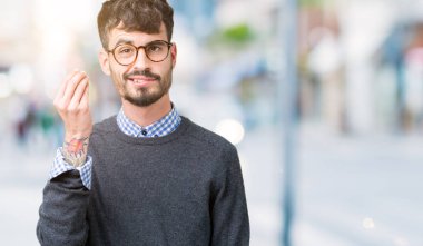 Genç yakışıklı zeki adam gözlük izole arka yapıyor İtalyan üzerinde el ve parmak emin ifadeyle jest