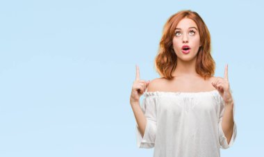 Genç güzel kadın izole arka plan üzerinden hayran ve yukarıya bakıp parmakları ile işaret şaşırttı ve silah kaldırdı.