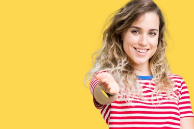 Güzel sarışın genç kadın dostu sunan el sıkışma tebrik ve davet edici olarak gülümseyen izole arka plan üzerinde. Başarılı iş.