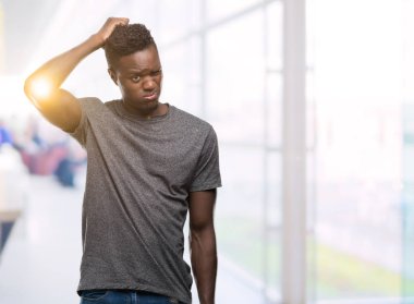 Gri t-shirt giyen genç Afro-Amerikan adam yanıltır ve soru hakkında merak ediyorum. Şüphe, kafasına el ile düşünme ile belirsiz. Dalgın kavramı.