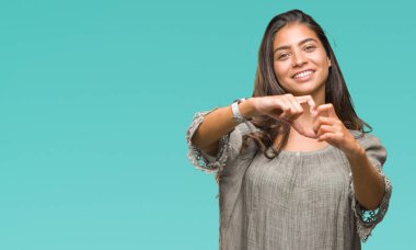 Genç güzel Arap kadın kalp simgesi ve elleriyle şekil gösterilen aşık gülümseyen izole arka plan yüzünden. Romantik kavramı.