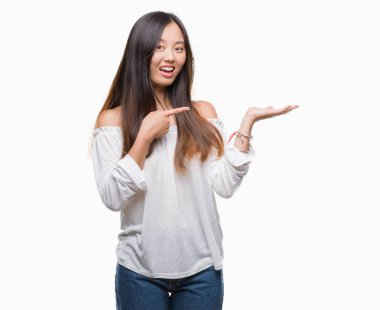 Genç Asyalı kadın üzerinden hayran ve el ile sunulması ve parmak ile işaret ederken kameraya gülümseyen izole arka plan.