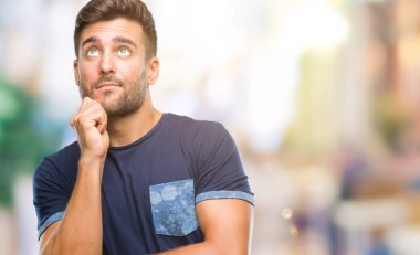 Yakışıklı delikanlı çene düşünme hakkında soru, dalgın ifade üzerine el ile izole arka plan üzerinde. Düşünceli yüzüyle gülümsüyor. Şüphe kavramı.