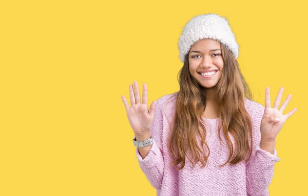 年轻美丽的黑发女人穿着毛衣和冬季帽在孤立的背景显示和手指指向 同时微笑着自信和快乐 — 图库照片
