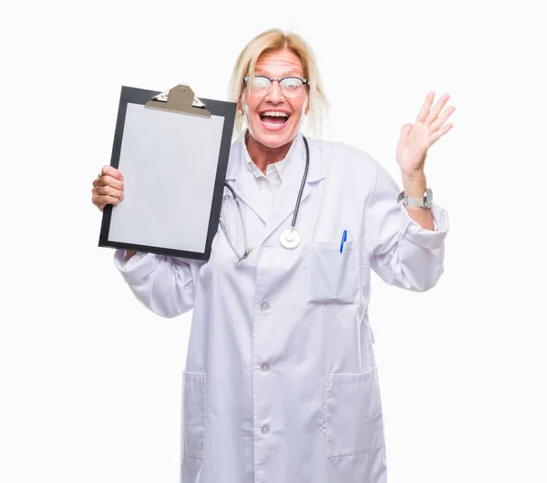 中年金发碧眼的医生女子拿着剪贴板在孤立的背景非常高兴和兴奋 获胜者的表情庆祝胜利尖叫着与灿烂的笑容和举起的手 — 图库照片