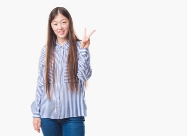 Gösterilen ve parmakları ile işaret izole arka plan üzerinde Genç Çinli kadın ikincisi ise kendinden emin ve mutlu gülümseyerek.