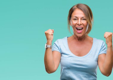 İzole arka plan kutlama üzerinde orta yaş İspanyol kadın kıdemli şaşırttı ve başarı için kaldırdı kollarını açarak hayret ve gözleri açık. Kazanan kavramı.