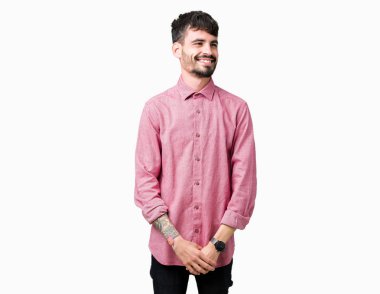 Uzak tarafına yüzünde, doğal ifade gülümseme ile seyir izole arka plan üzerinde pembe gömlek giymiş yakışıklı delikanlı. Kendine güvenen gülüyor.