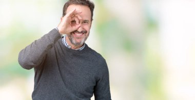 Yakışıklı orta yaş komuta sizde gülümseyen, parmakları ile mutlu yüz üzerinden seyir göz el ile ok jest yapıyor izole arka plan üzerinde bir kazak giyiyor.