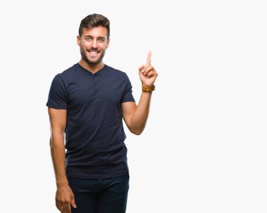 Kameraya bakarak yan el ve parmak ile işaret eden genç yakışıklı adam yüzünde kocaman bir gülümseme ile izole arka plan üzerinde.