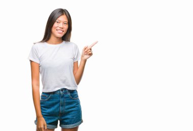 Kameraya bakarak yan el ve parmak ile işaret eden Genç Asyalı kadın yüzünde kocaman bir gülümseme ile izole arka plan üzerinde.