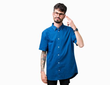 Genç yakışıklı adam gözlük izole üzerinde çekim ve öldürmek kendini el ve parmaklara baş, intihar jest işaret arka plan.