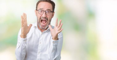 Üzerinde gözlük takan yakışıklı orta yaş zarif üst düzey iş adamı arka plan deli izole ve deli bağırarak ve agresif ifade ve silah kaldırdı bağırıyor. Hayal kırıklığı kavramı.