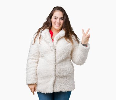 Artı boyutu genç kadın güzel kış koyun üzerine ceket giyen arka plan mutlu yüz zafer işareti yaparken kameraya göz kırpıyor ile gülümseyen izole. İki numaralı.