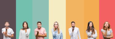 Kolaj bir öpücük el ile güzel ve seksi olmak hava üfleme kamera bakarak renkli çizgili izole arka plan üzerinde farklı etnik genç insan. Aşk ifade.