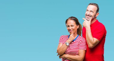 Orta yaş İspanyol çift emin çapraz kollar ve çeneme kaldırdı el ile gülümseme ile kameraya bakarak izole arka plan üzerinde aşık. Pozitif düşünce.