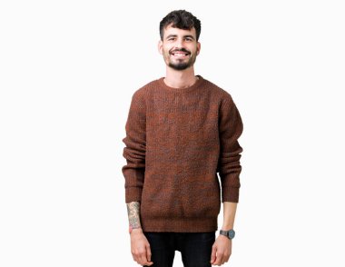 Yüzünde mutlu ve güzel bir gülümseme ile izole arka plan üzerinde kış kazak giyen genç yakışıklı adam. Şanslı kişi.