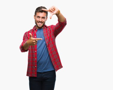 Yakışıklı delikanlı elle yapma çerçeve ve parmakları ile mutlu yüz gülümseyen izole arka plan üzerinde. Yaratıcılık ve Fotoğrafçılık kavramı.