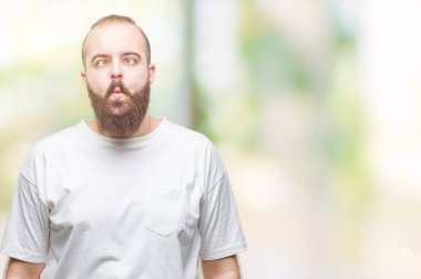 İzole arka plan yapma balık yüzüne dudaklı, çılgın ve komik bir jest rahat t-shirt giyen genç beyaz hipster adam. Komik ifade.