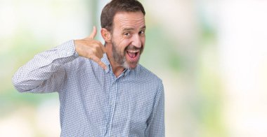 Yakışıklı orta yaş zarif komuta sizde yapıyor gülümseyen izole arka plan üzerinde telefon hareketi ile el ve parmak telefonda konuşuyor gibi. Kavramları iletişim.