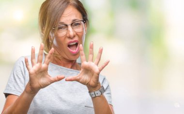 Şokta bağırarak korkuyor ve dehşet korku ifade dur hareketi el ile ile izole arka plan üzerinde gözlük takan orta yaş İspanyol kadın kıdemli. Panik kavramı.