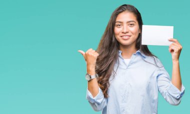 İşaret ve başparmak kadar mutlu yüz gülümseyen tarafı ile gösteren izole arka plan üzerinde boş kartı tutan genç Arap kadın