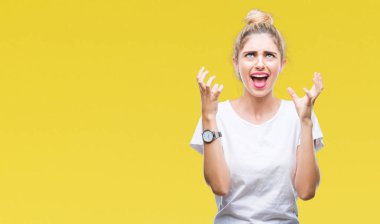 Genç güzel sarışın kadın üzerinde beyaz t-shirt giyen arka plan deli izole ve deli bağırarak ve agresif ifade ve silah kaldırdı bağırıyor. Hayal kırıklığı kavramı.