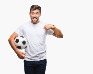 Sürpriz yüz işaret parmağı kendini izole arka plan üzerinde futbol futbol topu tutan genç yakışıklı adam