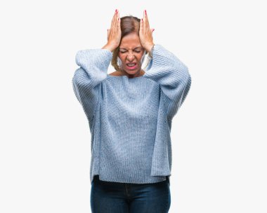 Çünkü çaresiz ve stresli baş ağrısı acı izole arka plan üzerinde kış kazak giyen orta yaş üst düzey İspanyol kadın ağrı ve migren. Ellerini kafasına.